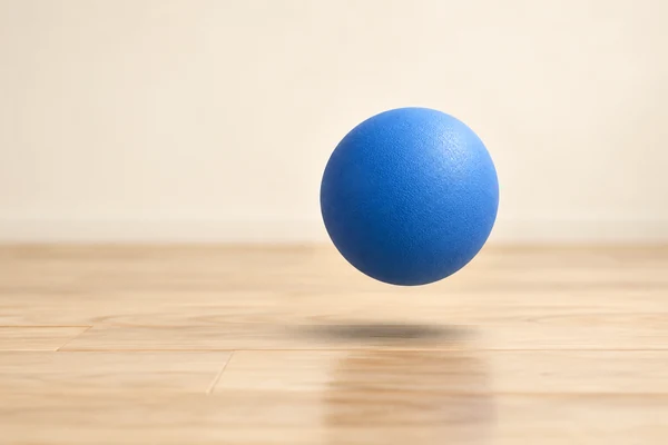 Erzeugte Illustration eines blauen Spielballs über einem hellen Holzboden mit einem weichen Schatten darunter